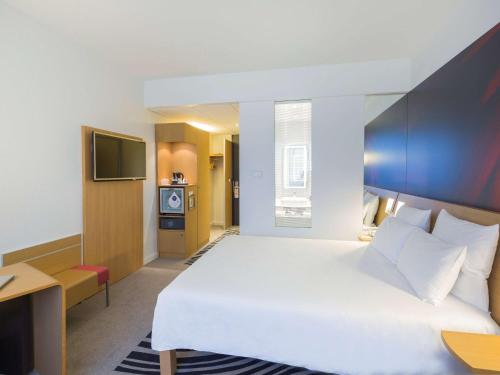 Postel nebo postele na pokoji v ubytování Novotel Poitiers Site du Futuroscope