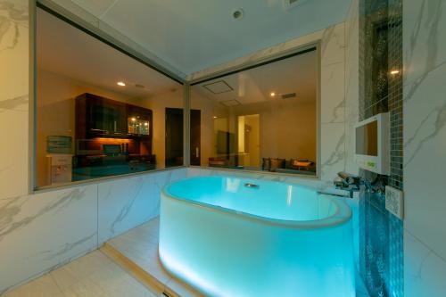 a large bathroom with a tub with a large mirror at i RESORT ARTIA Luxury Gifu (Adult Only) in Gifu