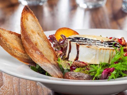 a plate of food with a salad and bread at Mercure Gdynia Centrum in Gdynia
