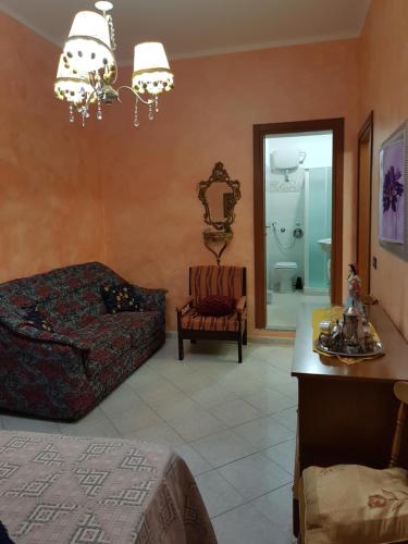a living room with a bed and a chair at Bed and breakfast Marilena in Montegiordano
