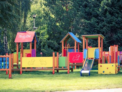 a group of colorful playground equipment in the grass at Mercure Gdańsk Posejdon in Gdańsk