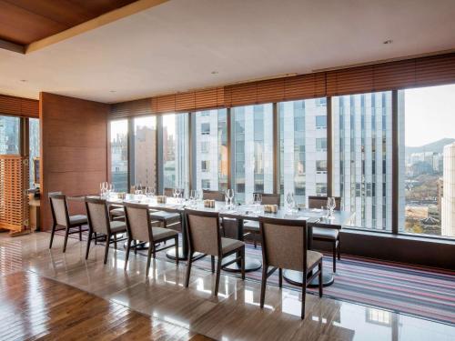 a dining room with a long table and chairs at Ibis Ambassador Myeongdong in Seoul