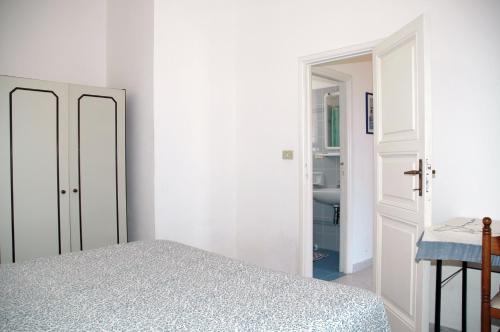 a white bedroom with a bed and a bathroom at Villa Oleandro in Capoliveri