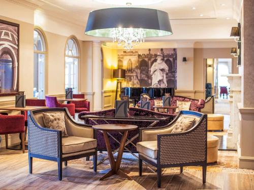 a lobby with chairs and a table and a chandelier at Mercure Exeter Southgate Hotel in Exeter