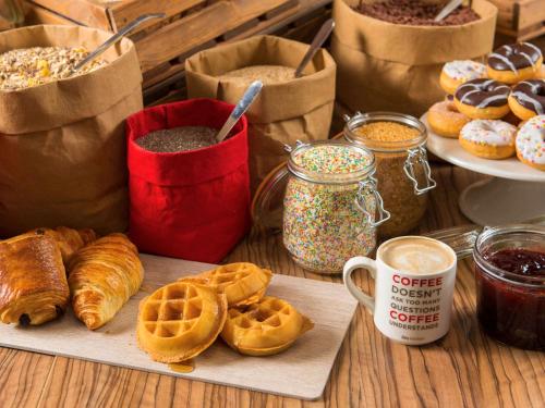 a table with waffles and other breakfast foods and drinks at Ibis Lleida in Lleida