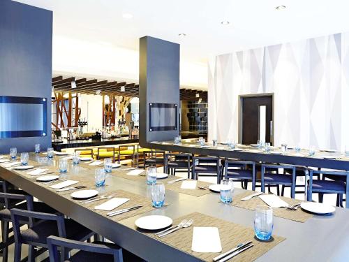 a large dining room with a long table and chairs at Novotel London Brentford in Brentford