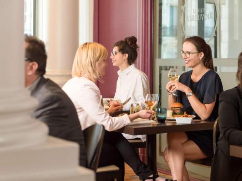 a group of women sitting at a table with wine glasses at Mercure Lille Roubaix Grand Hôtel in Roubaix