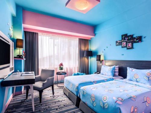 a bedroom with a bed and a desk and a computer at Mercure Serpong Alam Sutera in Serpong