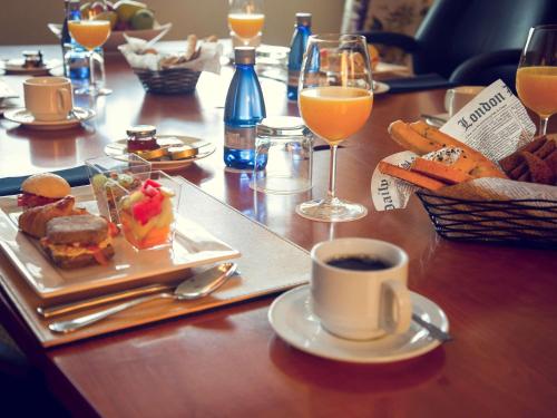 a table with a plate of food and a cup of coffee at Mercure Santiago Centro in Santiago
