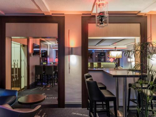a bar in a restaurant with chairs and a table at Mercure Paris Velizy in Vélizy-Villacoublay