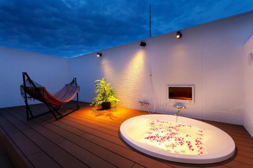 a bath tub sitting on a wooden deck with a hammock at Hotel Eldia Yamanashi (Adult Only) in Fuefuki