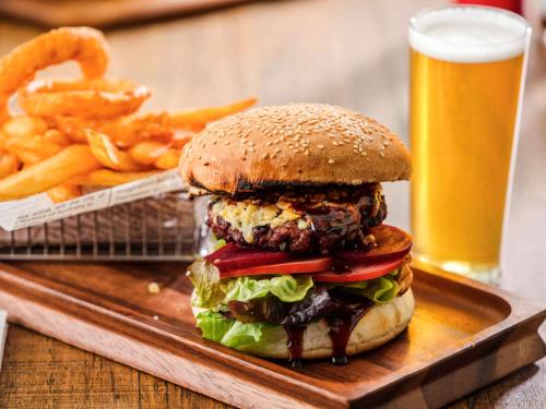a hamburger and french fries and a glass of beer at Ibis Mackay in Mackay