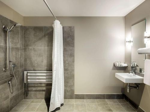 a bathroom with a shower curtain and a sink at Ibis Mackay in Mackay