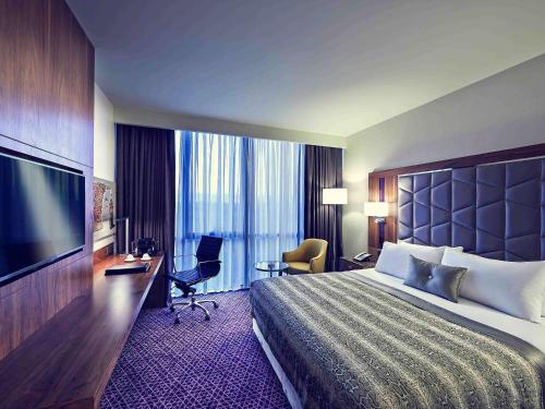 a hotel room with a large bed and a flat screen tv at Uranus Istanbul Topkapi in Istanbul