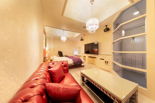 a living room with a couch and a bed at Hotel Eldia Yamanashi (Adult Only) in Fuefuki