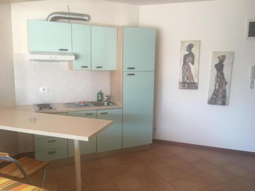 een keuken met blauwe kasten en een tafel. bij Apartments Boka Residence in Herceg-Novi