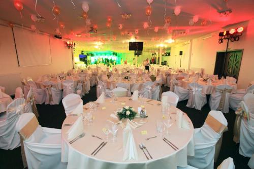 a banquet hall with white tables and chairs at Dixon Resort in Banská Bystrica