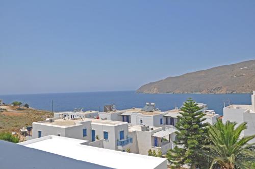 a group of white buildings with the ocean in the background at Studios Akrogiali in Aegiali