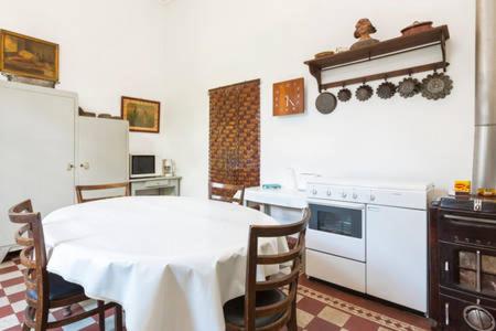 - une cuisine avec une table et une table et des chaises blanches dans l'établissement Bel Appartement Dans Cloitre Arbore, à Villeneuve-lès-Avignon