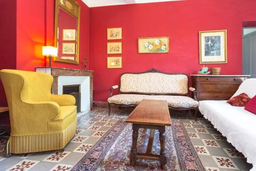 ヴィルヌーヴ・レ・ザヴィニョンにあるBel Appartement Dans Cloitre Arboreの赤いリビングルーム(ソファ、椅子付)