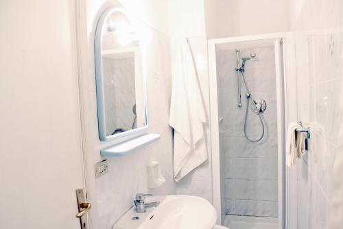 een witte badkamer met een wastafel en een douche bij Villa Cedro in Capoliveri