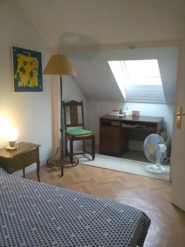 1 dormitorio con cama, escritorio y ventana en Chantilly, en Orvault