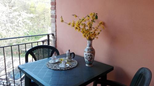 une table avec un vase de fleurs et une table avec un vase dans l'établissement Antica Dimora, à Sarnano