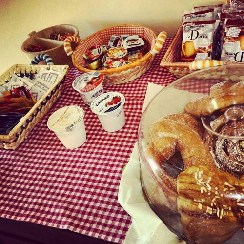 uma mesa vermelha e branca com doces e outras comidas em Agriturismo Al Rifugio DiVino em Belvedere Ostrense