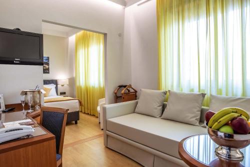 a living room with a couch and a table with a bowl of fruit at Hotel La Giocca in Rome