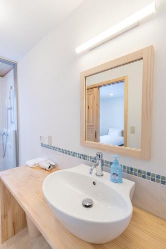 a bathroom with a sink and a mirror at Lodge Mori Apartments in Kutchan