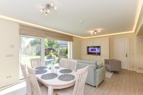 a dining room with a table and a couch at Vila Laurus in Palanga