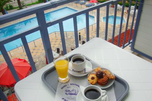 a table with a tray of food and drinks on a balcony at Hotel Pantazis in Paralia Panteleimonos