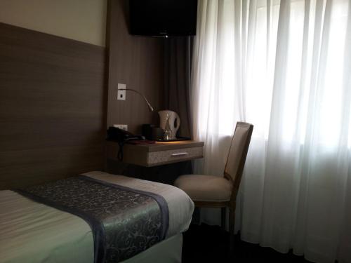 a hotel room with a bed and a chair and a window at The Concert Hotel in Amsterdam