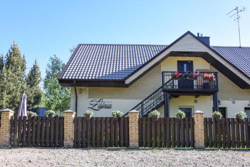 a house with a fence in front of it at Vila Laurus in Palanga