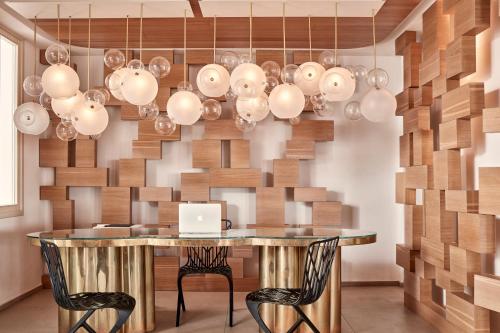 a dining room with a table with a laptop on it at Myconian Naia - Preferred Hotels & Resorts in Mýkonos City