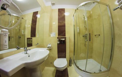 a bathroom with a sink and a shower and a toilet at Hotel Pikul in Puławy