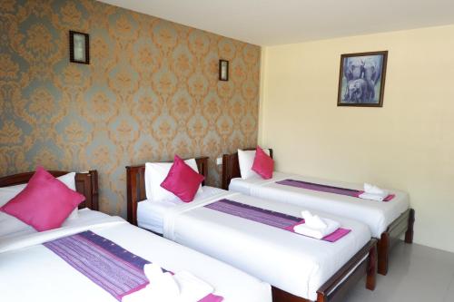 two beds in a room with pink and white pillows at Phi Phi Maiyada Resort in Phi Phi Don