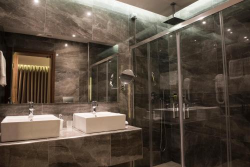a bathroom with two sinks and a glass shower at Mistral Hotel in Paralia Katerinis