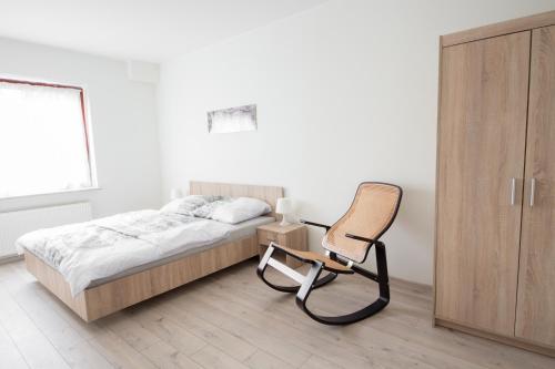 オストルフ・ビエルコポルスキにあるApartament Zebcowskaのベッドルーム1室(ベッド1台、椅子付)