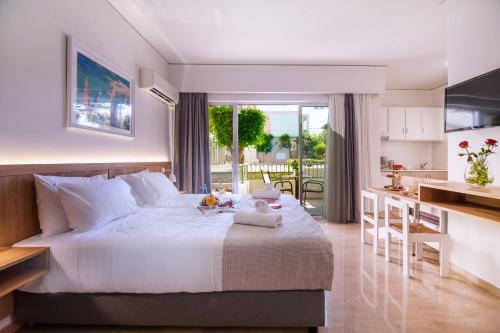 カト・ダラトソにあるLotus Hotel Apartmentsのベッドルーム(大きな白いベッド1台付)、キッチンが備わります。