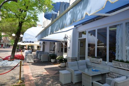 a store with couches and tables outside of a building at Hotel Villa Erica in Grado