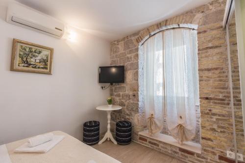 una camera da letto con un muro di mattoni e una finestra di Apartments Centrum Split a Spalato (Split)
