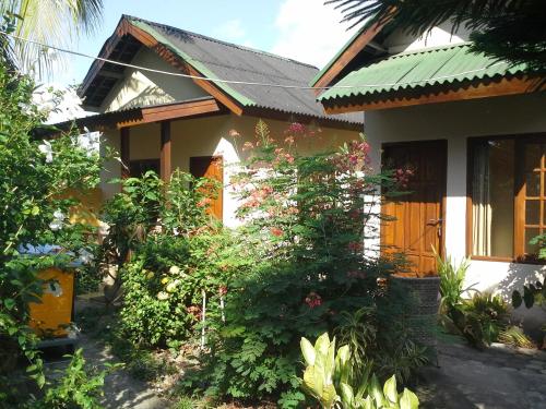 uma casa com muitas plantas à frente dela em Arnel Bungalows em Senggigi