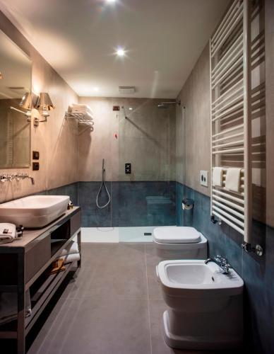 a bathroom with two toilets and a sink and a shower at Aqua Apartments in Venice