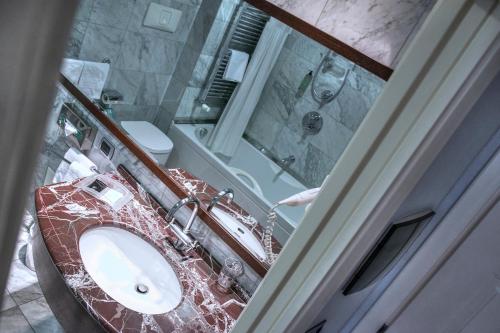 a bathroom with a sink and a toilet and a mirror at Italiana Hotels Cosenza in Cosenza