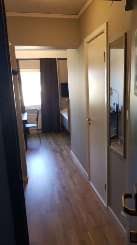 a room with a hallway with a door and a table at City Hotel in Kristinehamn
