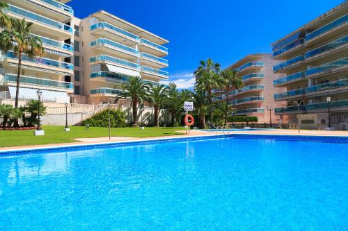 a large swimming pool in front of a building at UHC Village Park Apartments in Salou