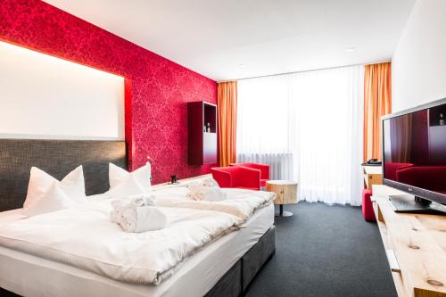 a hotel room with a large bed and a flat screen tv at Hotel Tannhof in Feldberg