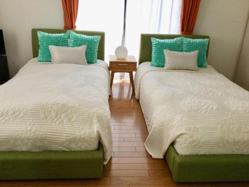 dos camas sentadas una al lado de la otra en una habitación en La Curación, en Naoshima