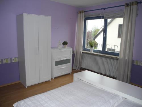 1 dormitorio con cama blanca y ventana en Ferienwohnung Meyenburg en Schwanewede